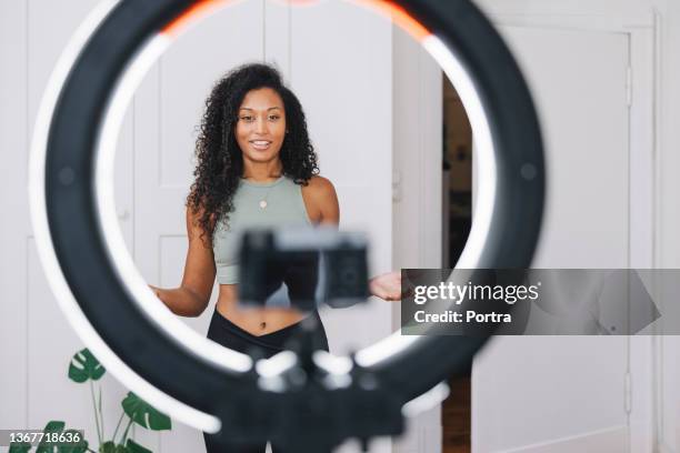 woman fitness trainer live streaming video on smartphone - using ring light stock pictures, royalty-free photos & images