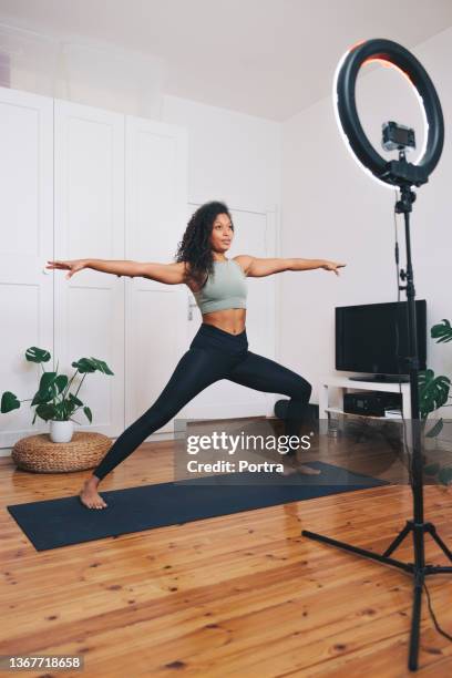 fitnesstrainer live-streaming-yoga-training von zu hause aus - frau macht yoga stock-fotos und bilder