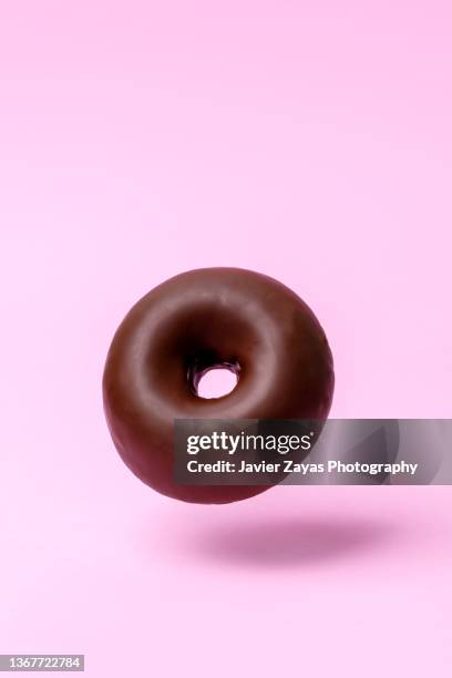 chocolate doughnut on pink colored background - チョコレートケーキ ストックフォトと画像