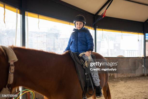 little boy riding training horse - sports training bildbanksfoton och bilder