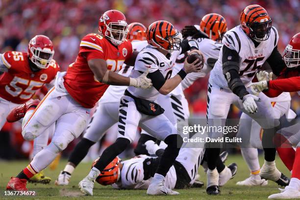 Quarterback Joe Burrow of the Cincinnati Bengals eludes the tackle of defensive end Chris Jones of the Kansas City Chiefs in the fourth quarter of...