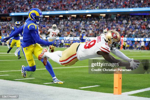 Deebo Samuel of the San Francisco 49ers dives to score a touchdown in the second quarter against Jalen Ramsey of the Los Angeles Rams in the NFC...