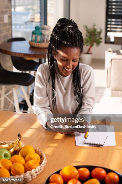 woman using mobile phone in kitchen. - telephone banana stock pictures, royalty-free photos & images