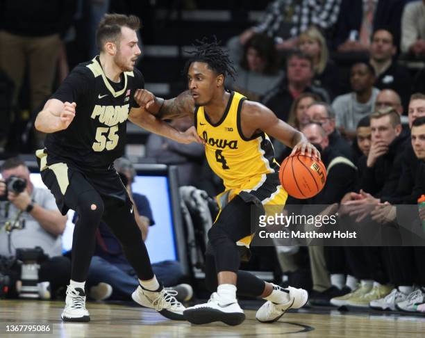 Guard Ahron Ulis of the Iowa Hawkeyes drives down the court during the first half against guard Sasha Stefanovic of the Purdue Boilermakers at...
