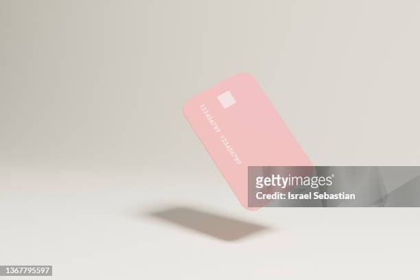 digitally generated image of a pink credit card floating on isolated background. - credit card stock-fotos und bilder