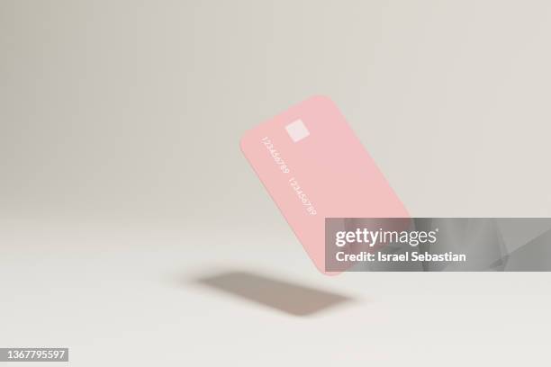 digitally generated image of a pink credit card floating on isolated background. - debit card ストックフォトと画像