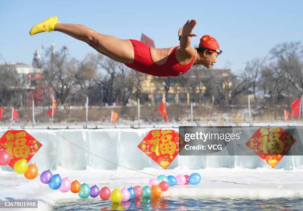 Winter swimmer jumps into a pool in the frozen Songhua River during an activity for welcoming the Chinese New Year on January 30, 2022 in Harbin,...