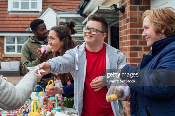 paying for an item at a yard sale - an evening with suggs friends in aid of pancreatic cancer uk stockfoto's en -beelden