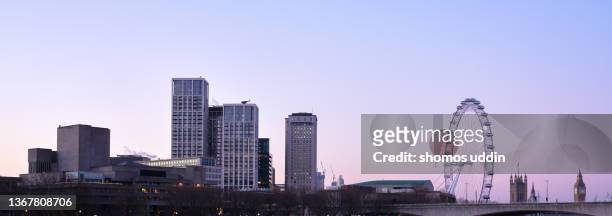 panoramic cityscape of london across the southbank of thames - big ben london eye dusk stockfoto's en -beelden