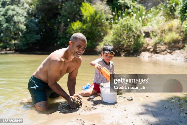 pouring wet clay into bucket. - new zealand family stock pictures, royalty-free photos & images