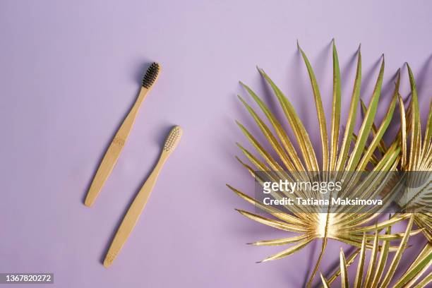 bamboo tooth brushes. zero waste concept. - brushed gold background stock pictures, royalty-free photos & images