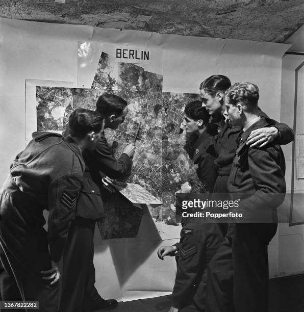 With the aid of an intelligence officer, Royal Air Force pilot Len Slade and fellow crew members study a map of Berlin prior to taking part in an...