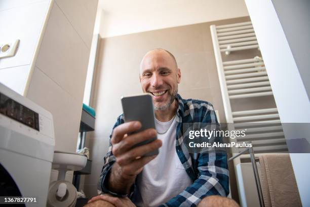 mann mit seinem handy auf der toilette - mobile phone reading low angle stock-fotos und bilder