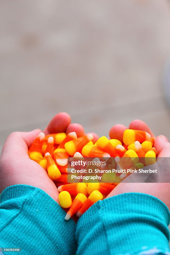 Hands holding candy corn heart