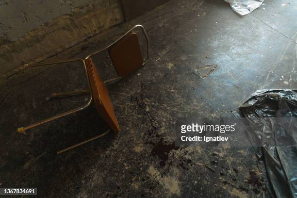 uma cena de crime com uma cadeira caída e um ponto de sangue em um quarto abandonado - murder photos - fotografias e filmes do acervo