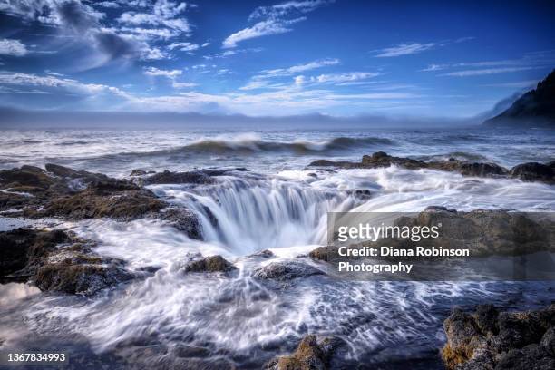 water flowing back into thor's well at high tide, while fog rolls into cape perpetua, oregon coast - oregon coast stock-fotos und bilder