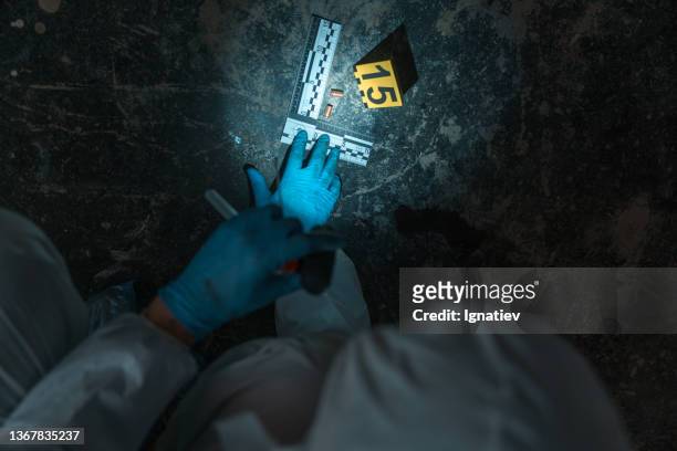 picture of physical evidence on the floor, with a crime scene number and two bullets - police flashlight stock pictures, royalty-free photos & images