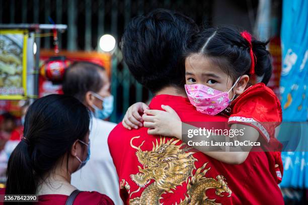 Little girl in a Chinese New Year themed outfit hugs her father on January 31, 2022 in Bangkok, Thailand. Due to the rise in COVID-19 cases, the...