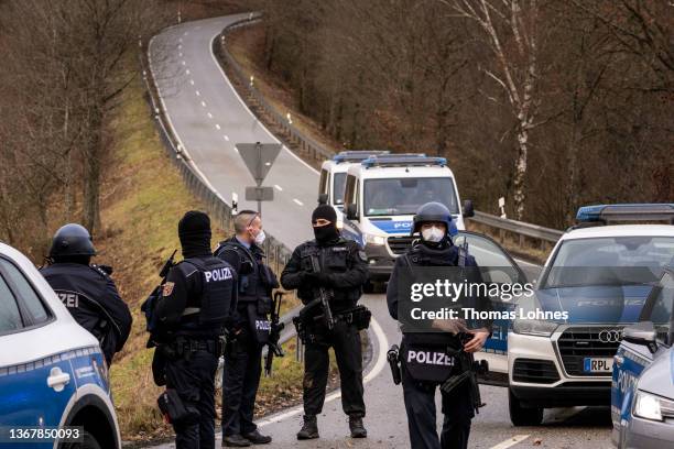 Police officers stand at a road leading to the scene of a shooting that left two police officers dead in Ulmet on January 31, 2022 near Kusel,...