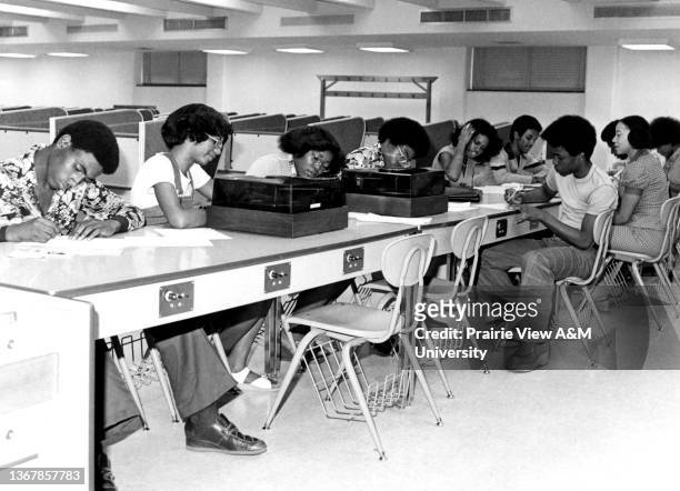 African American female and male students working on assignments at the W.R. Banks Library at Prairie View A&M University in Prairie View, TX, 1970s.