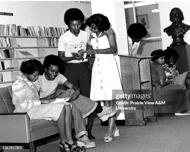 Students engaging in a conversation and reading books at Prairie View A&M University. Prairie View, TX, 1970s.