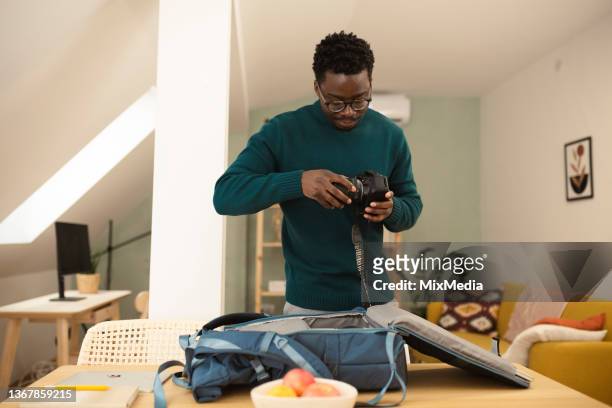 young african-american photographer-freelancer preparing for work - camera bag stockfoto's en -beelden