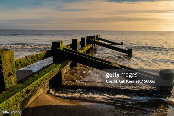 groyne on the beach,scenic view of sea against sky during sunset,promenade,skegness,united kingdom,uk - skegness stock-fotos und bilder