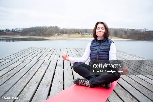 mature woman exercising outdoors. - grey pier stockfoto's en -beelden