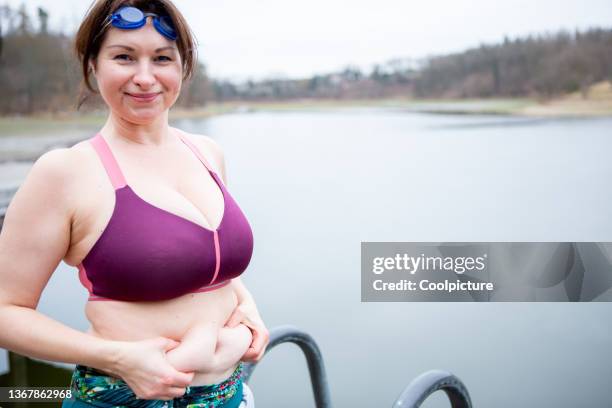 mature overweight woman swimming in the winter.. - extreme dieting stock pictures, royalty-free photos & images