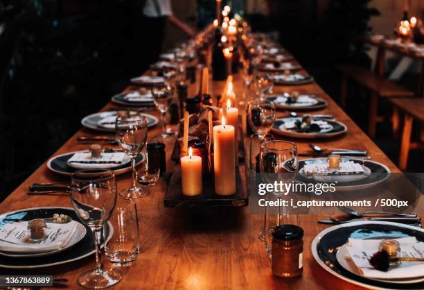 evening well spent,high angle view of lit candles on dining table - eettafel stockfoto's en -beelden