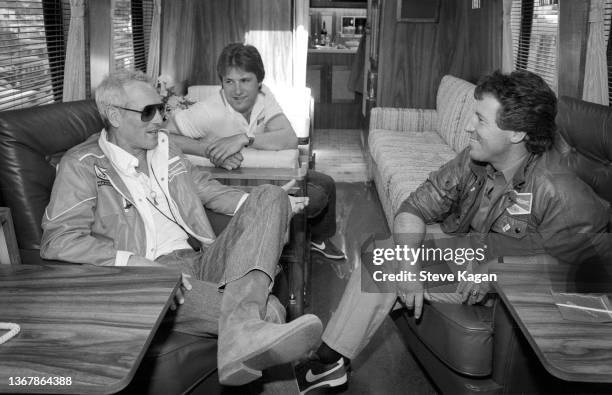 View of, from left, American actor Paul Newman and race car drivers Michael Andretti and his father, Mario Andretti, as they talk together at the...