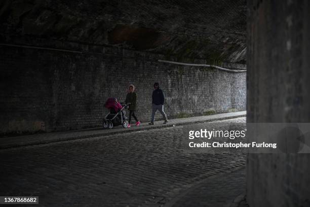 People walk beneath a railway bridge that retains the original cobbled road in the Horseley Fields area of Wolverhampton which is earmarked for...