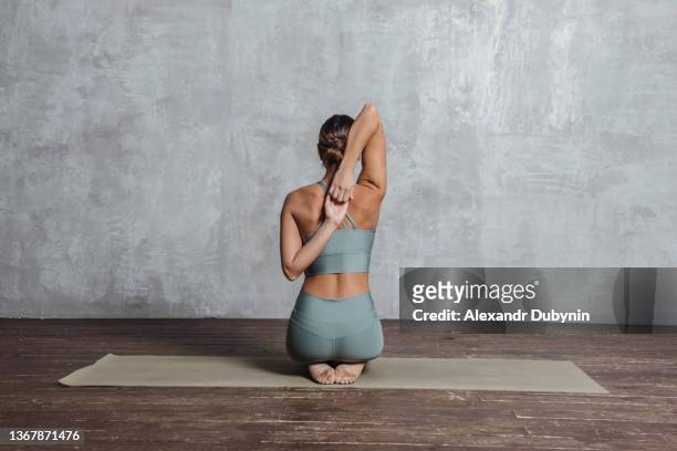back yogi woman doing yoga exercises on the floor sitting with hands together. - pilates fotografías e imágenes de stock