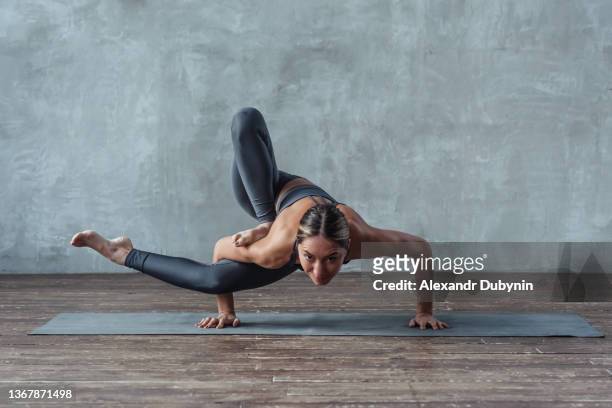 athletic strong woman doing yoga exercise pose standing on hands. - yoga flexibility stock pictures, royalty-free photos & images