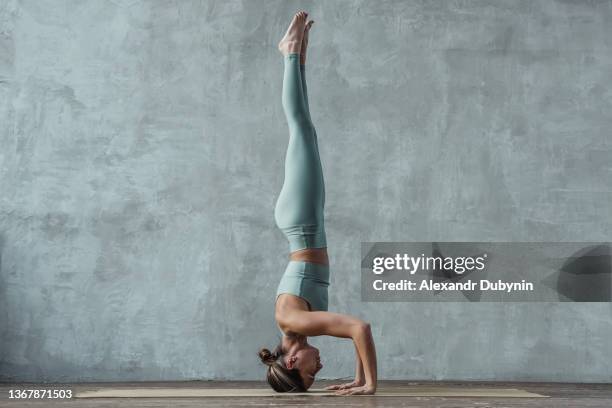 yogi woman doing yoga exercises in headstand pose. - headstand ストックフォトと画像