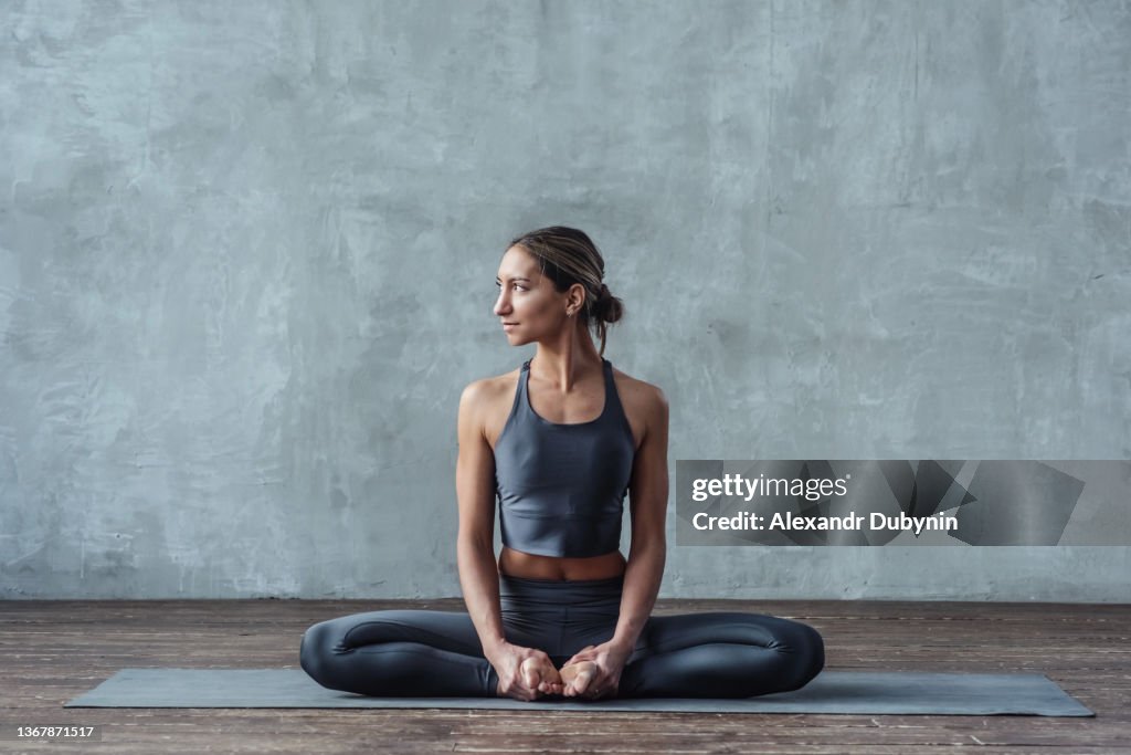 женщина сидит в позе бабочки йога студия