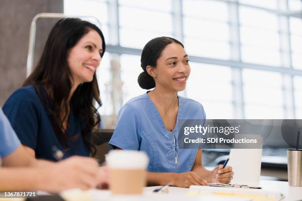 female nursing students smile during lecture - nurse candid stock pictures, royalty-free photos & images