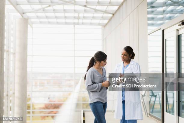 el médico explica los resultados de las pruebas del paciente a un miembro de la familia - conversations fotografías e imágenes de stock