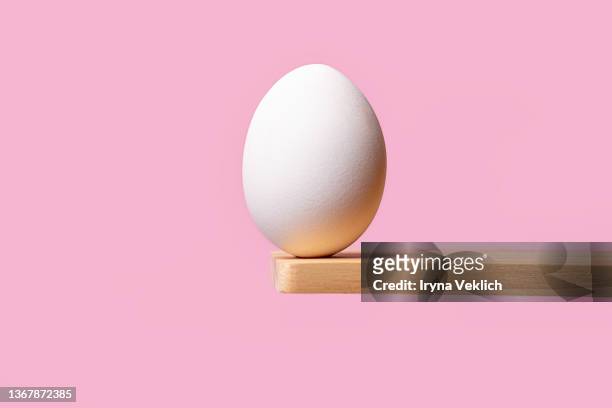 white color easter egg on pastel pink color background.  easter minimal concept. - hard boiled eggs stock-fotos und bilder