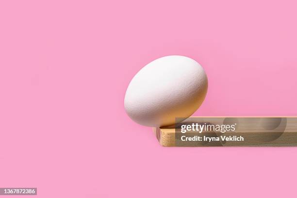 white color easter egg on pastel pink color background.  easter minimal concept. - balançoire à bascule photos et images de collection