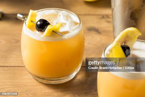 sweet homemade whiskey amarreto sour,close-up of drinks on table - whiskey sour stock pictures, royalty-free photos & images