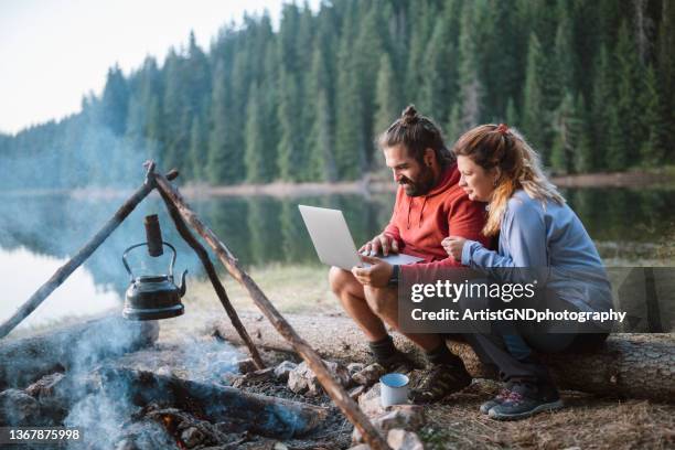 usare la tecnologia in campeggio. - coppia bosco romantico foto e immagini stock