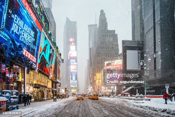 traffic and heavy snow at times square midtown manhattan. incidental people seen on the streets - new york city snow stock pictures, royalty-free photos & images