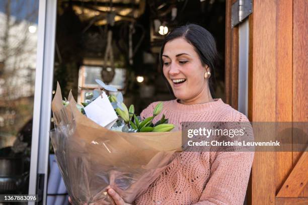 happy client receiving a flower bouquet - receiving flowers stock pictures, royalty-free photos & images