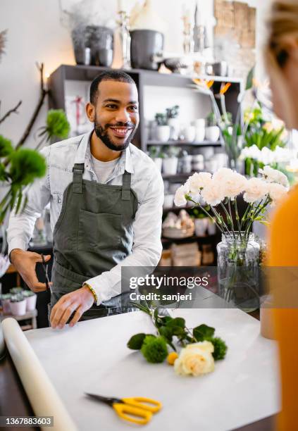 florist arbeitet im blumenladen - florista stock-fotos und bilder