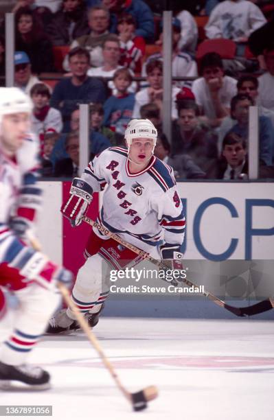 Adam Graves, of the New York Rangers, following teammate Joe Cirella who is carrying the puck out of the Rangers zone during game against the New...