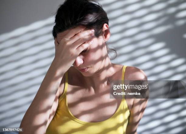 woman suffering from headache sitting on floor - aura stock pictures, royalty-free photos & images