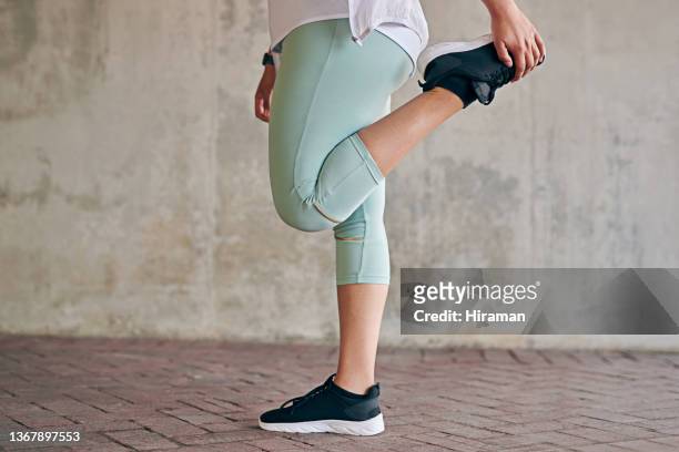 primer plano de una mujer deportista estirando las piernas mientras hace ejercicio al aire libre - standing on one leg fotografías e imágenes de stock