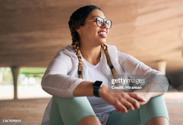 shot of a sporty young woman taking a break while exercising outdoors - wellbeing stock pictures, royalty-free photos & images