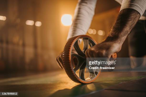 exercise with ab roller - endurance training stock pictures, royalty-free photos & images
